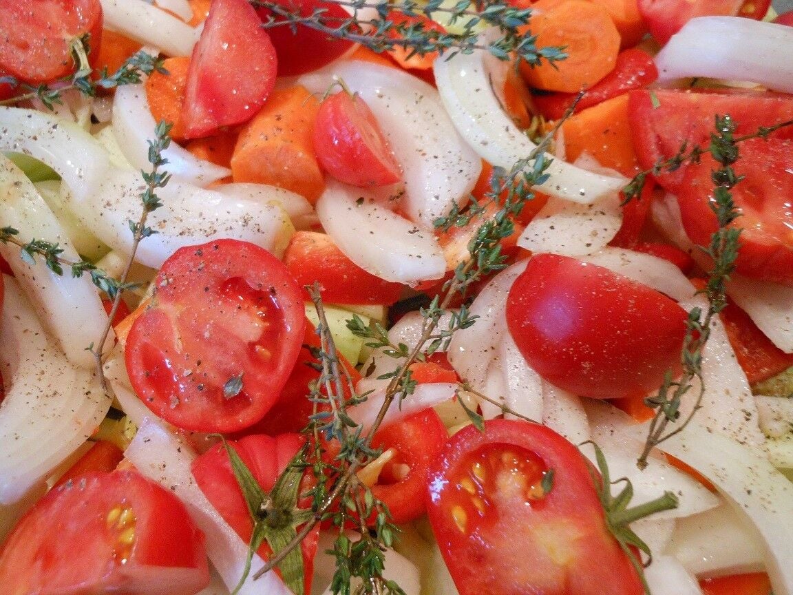 Slices onions, tomatoes, and thyme in bowl.