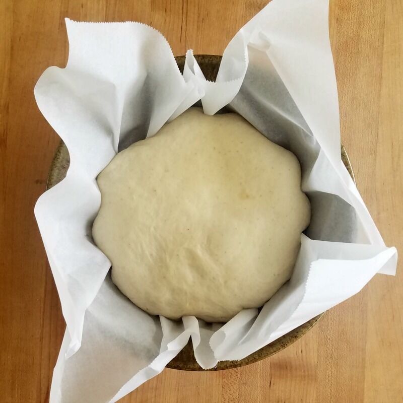 Dough rising in parchment in bowl. 