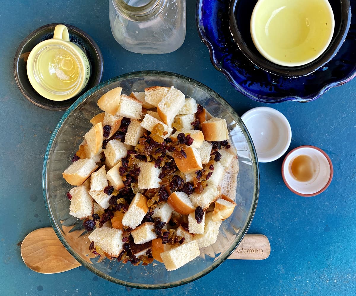 Bread cubes and dried fruit added to pudding custard mix.