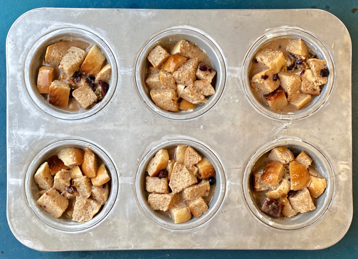Prepared bread pudding mix in large muffin tins; ready to bake.