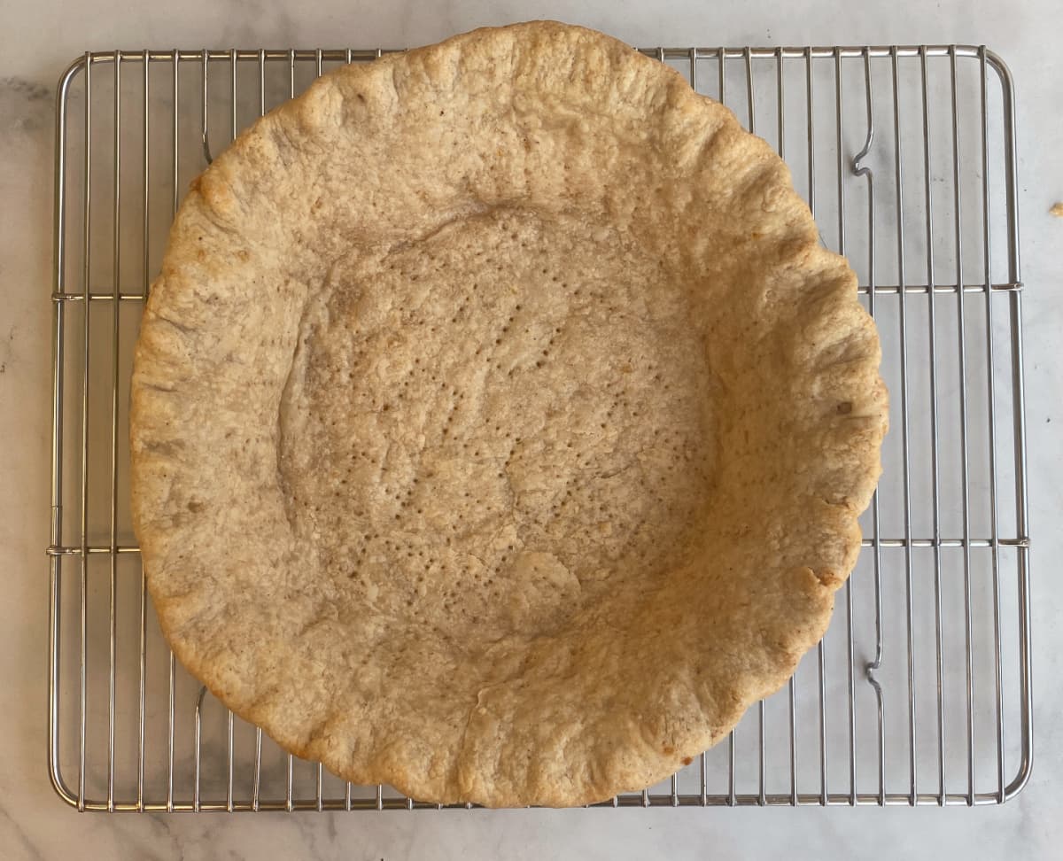 Parbaked pie shell cooling on a wire rack.