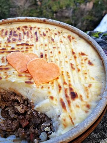 Shepherd's pie with a large serving taken out so that the inner filling shows.