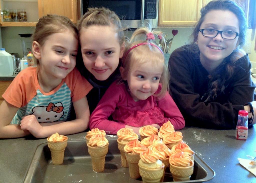 Four children with ice cream cone cupcakes.