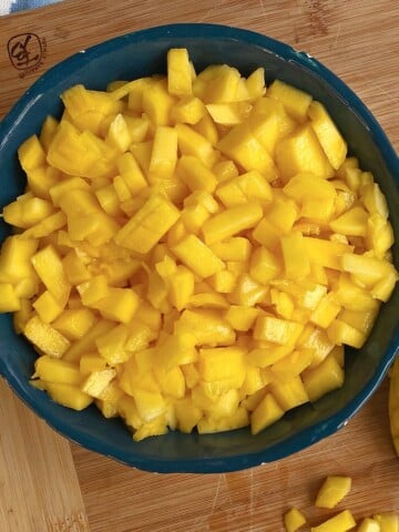Block pottery bowl filled with diced mangos.