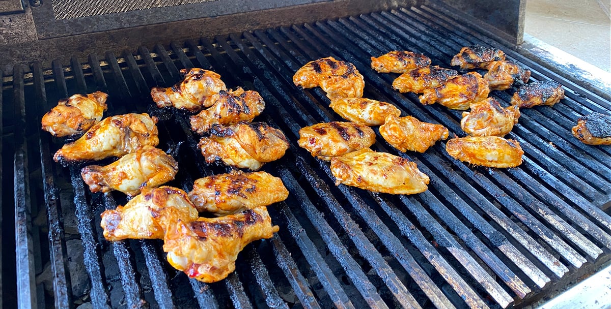 Buffalo Wings grilling on outdoor BBQ. 