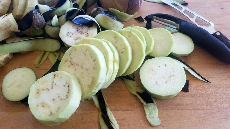 Sliced, peeled eggplant on counter. 