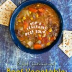 A bowl of vegetable soup, with saltine crackers strewn at the foot of the bowl. Alphabet letters spell out "Pop's Vegetable Beef Soup" across the top of the soup. Pin Text reads: Old-fashioned Beef Vegetable Soup