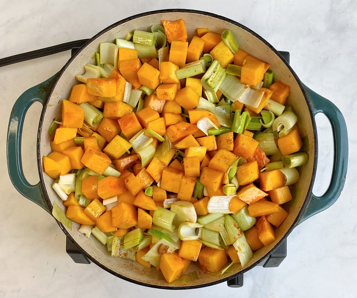 Butternut and leeks tossed with bacon-honey sauce in skillet.  