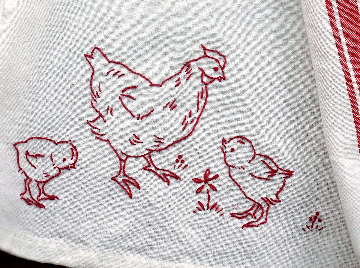 Redwork embroidered chicken and two chicks, on an old-fashioned red-lined tea towel.