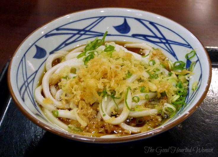 Marukame Udon in a noodle bowl, topped with green onions. 