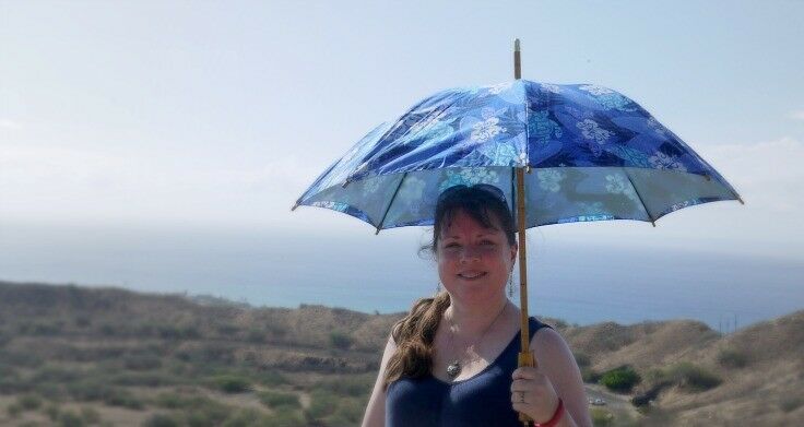 Me, halfway up Diamond Head,  holding a tropical fabric-covered umbrella to shield the sun. 