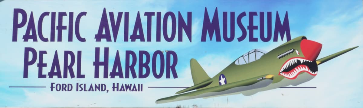 Sign from the Pearl Harbor Aviation Museum (before 2019 name change) with a Flying Tigers plane in lower right.