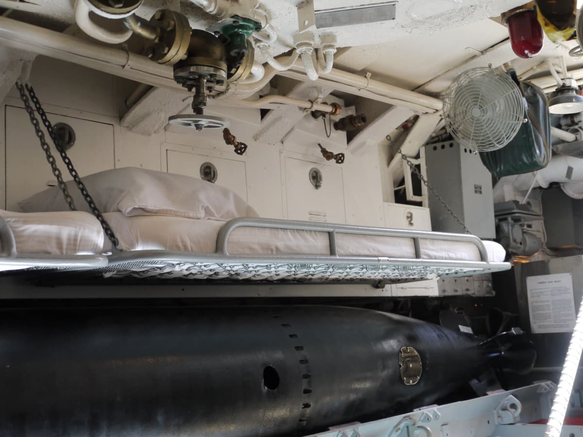 Torpedoman's rack, resting above a torpedo.