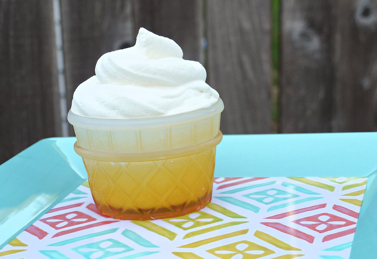 Copycat Dole Whip in an ice cream cone-shaped bowl of a summery square serving tray. 