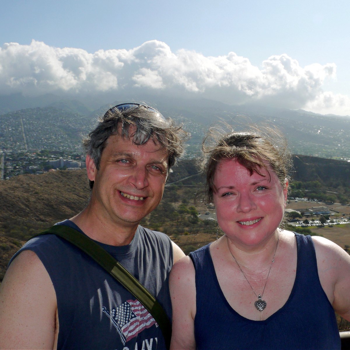 Sweaty, happy couple standing on top of Diamond Head. 