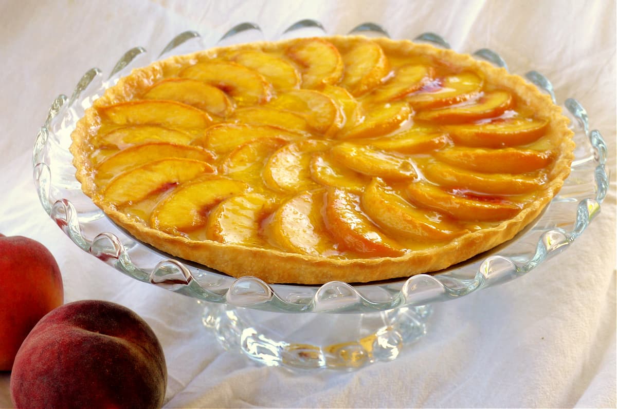 This easy, breezy Peach Custard Tart is light, creamy, and perfectly sweet; infused with a hint of cardamom, it's a fresh summer treat that always leaves them wanting more.