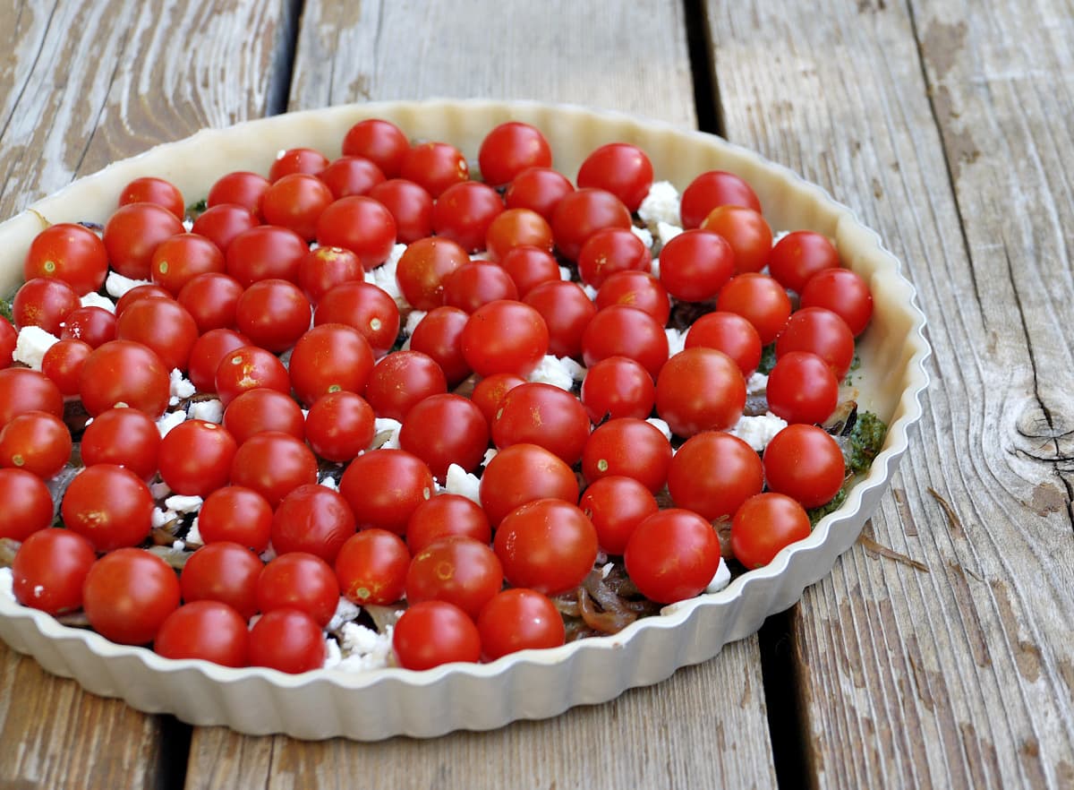 Ingredinets for tomato tart include cherry tomatoes, feta, and pie crust. 
