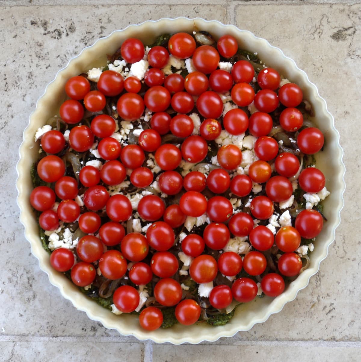 Overhead shot of cherry tomatoes covering an unbaked tart.