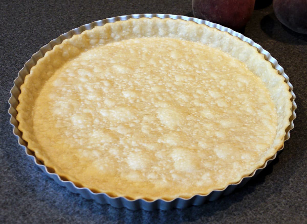 Tart pastry after blind baking; slightly browned, in tart pan.