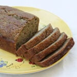 Loaf of zucchini-banana bread, sliced on a hand-painted plate.
