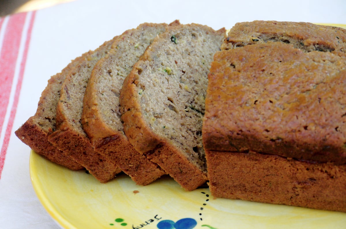 four slices of zucchini-banana bread on a hand-painted plate.