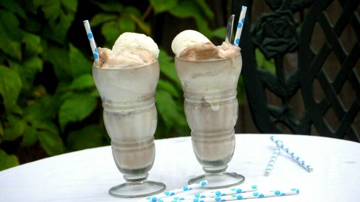 Two Old-fashioned Chocolate Ice Cream Sodas in soda glasses with aqua polka-dot straws.
