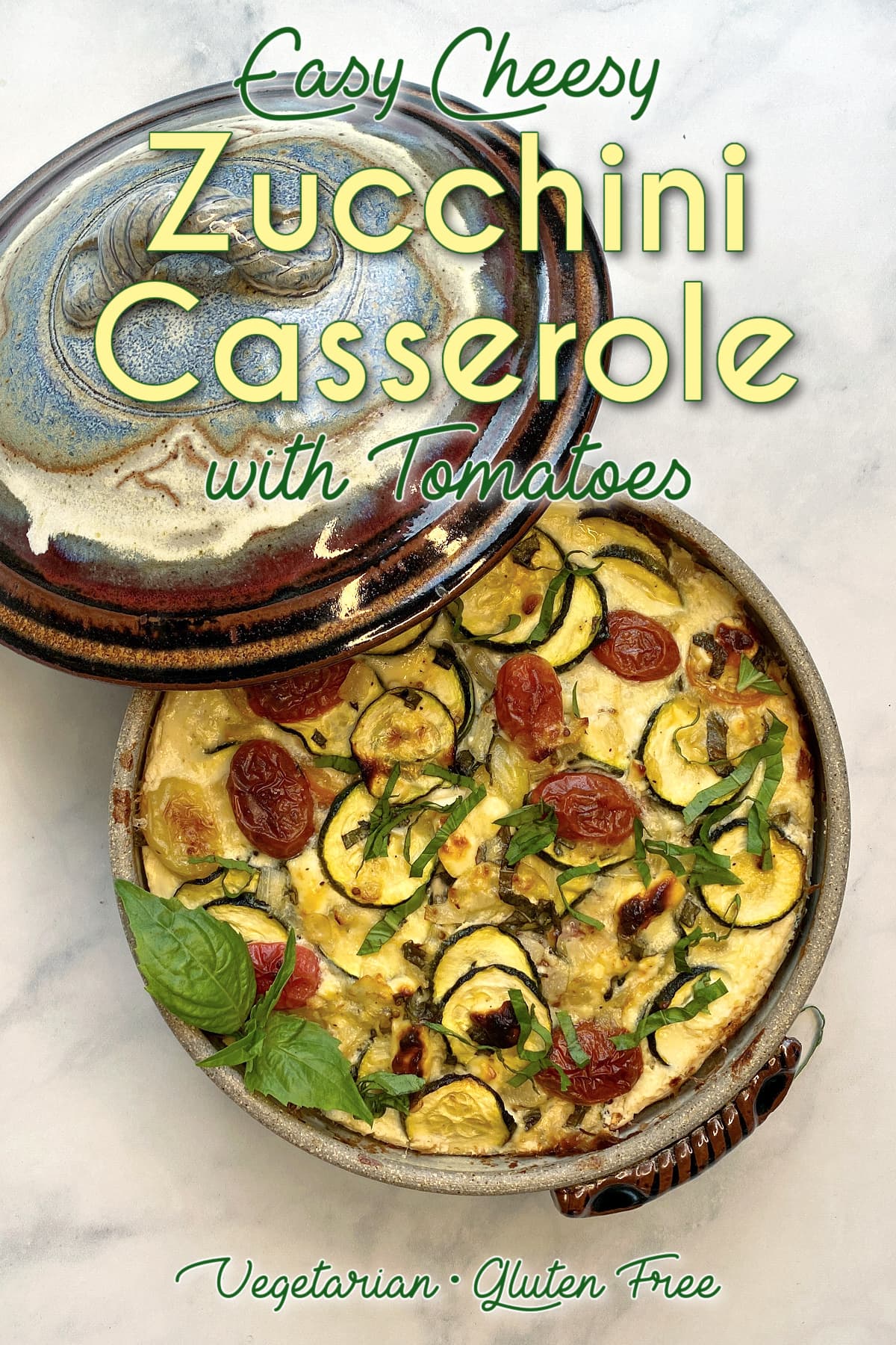 Baked zucchini casserole with tomatoes in a crockery casserole dish, garnished with chiffonaded basil. Casserole lid leaning on the side. Pin text reads: Easy Cheesy Zucchini Casserole with Tomatoes, vegetarian • gluten-free