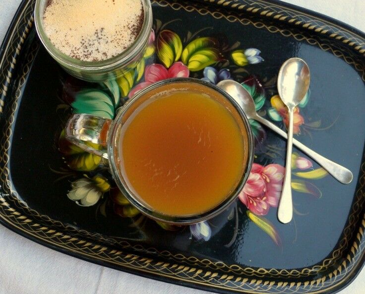 Hand-painted Russian tea tray with flowers on a black background, gold painted trim. Cups and spoons on tray. 