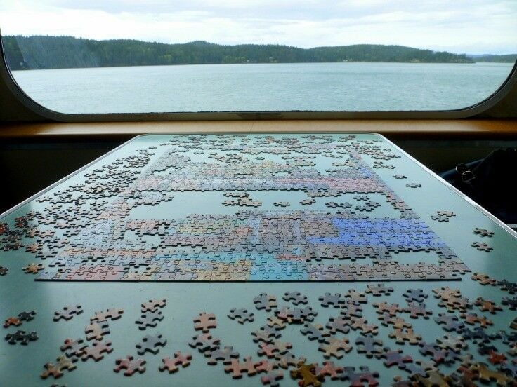 Half-finished puzzle on a table on the Washington State Ferry to Orcas Island. Out-looking the water on the Sound. 