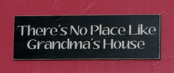 Black sign on red background, reading: There's No Place Like Grandma's House. 