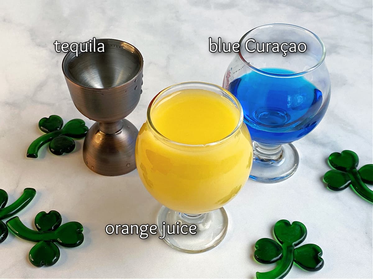 Ingredients for an Emerald Sunrise displayed in small glasses.