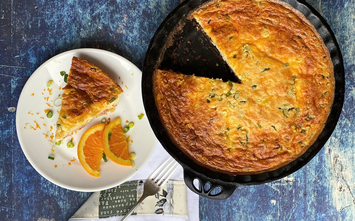 Overhead shot of on slice of pie on plate, garnished with orange slices, and remaining pie in pie dish to the side. 