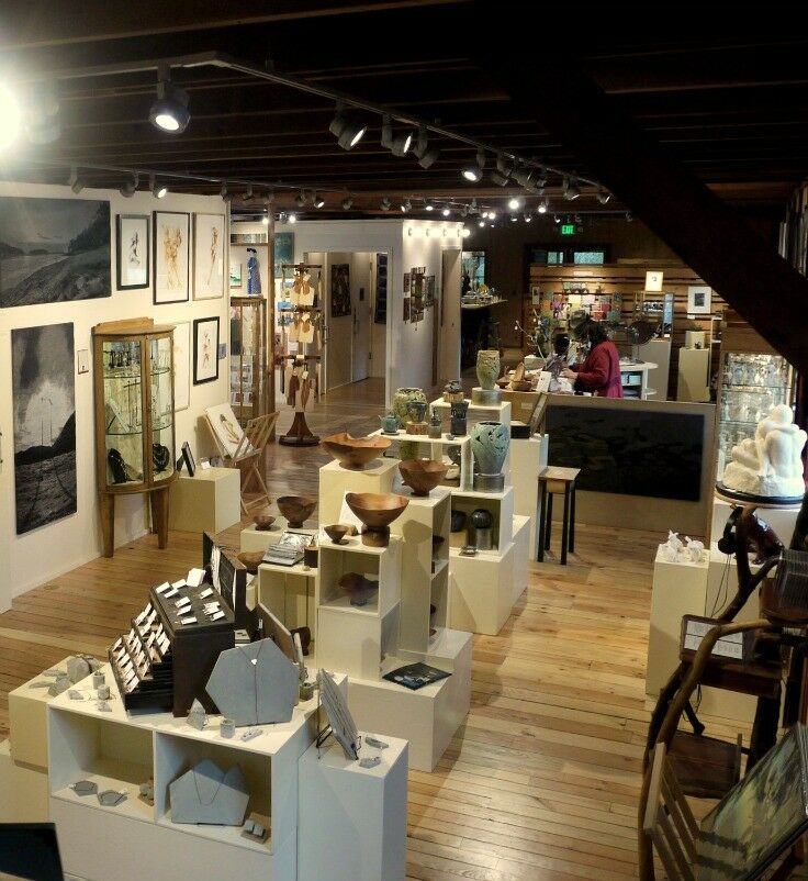 Wide interior of Orcas Island Artworks, with a large variety of pottery, fabric arts, and paintings displayed. 