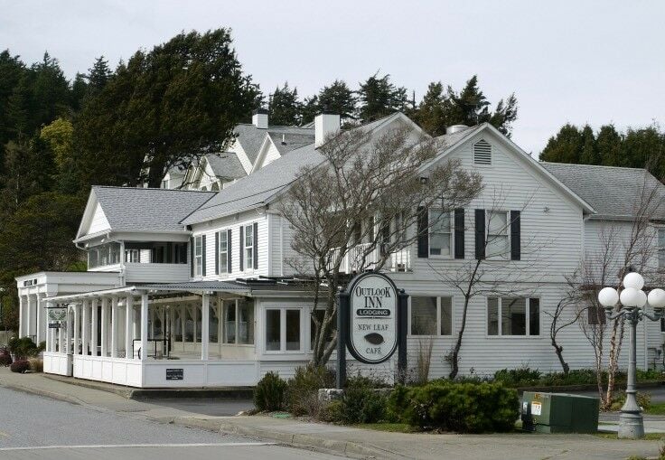 Exterior view of Outlook Inn; three stories, white with black trim. 