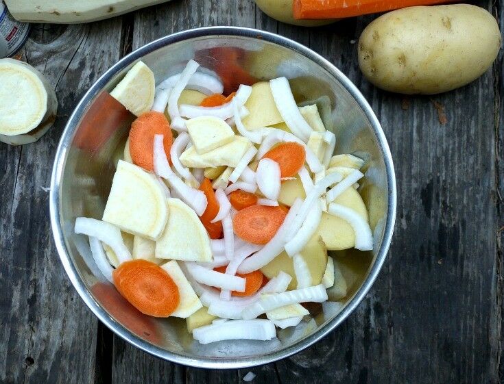 Bowl with mixed carrots, potatoes, and onions. 