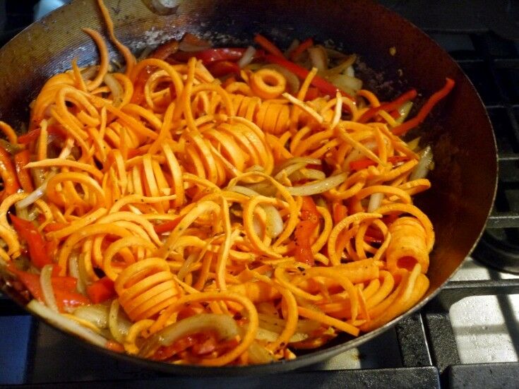 Sweet potato noodles cooking in a wok.