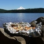 Scenic shot of foil stew, cooked and opened, with Trilliam Lake and Mount Hood int he background.