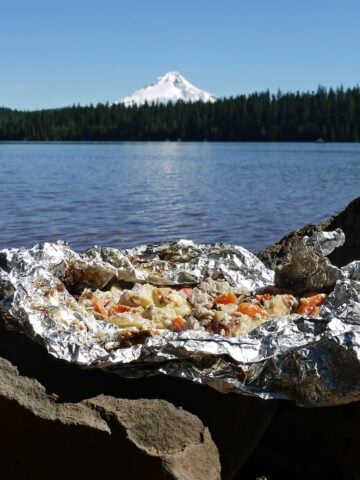 Scenic shot of foil stew, cooked and opened, with Trilliam Lake and Mount Hood int he background.
