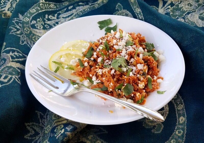 Moroccan Carrot Salad on a plate, with a fork angled across the front. 