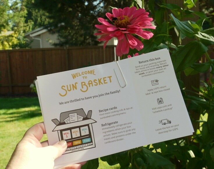 Sunbasket recipe cards in hand.