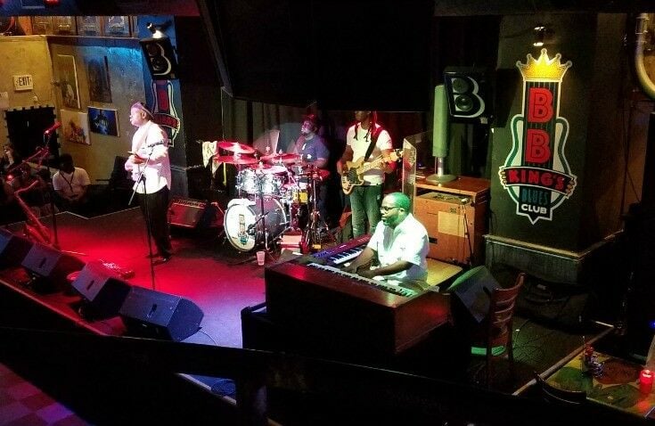 BB King All-Star Band on stage at the Blues Club: piano player in duel-V set-up, drummer with set, bass player. 