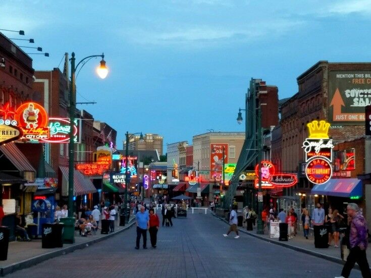 Closer view looking down the middle Beale Street, with neon signs lighted on both sides.