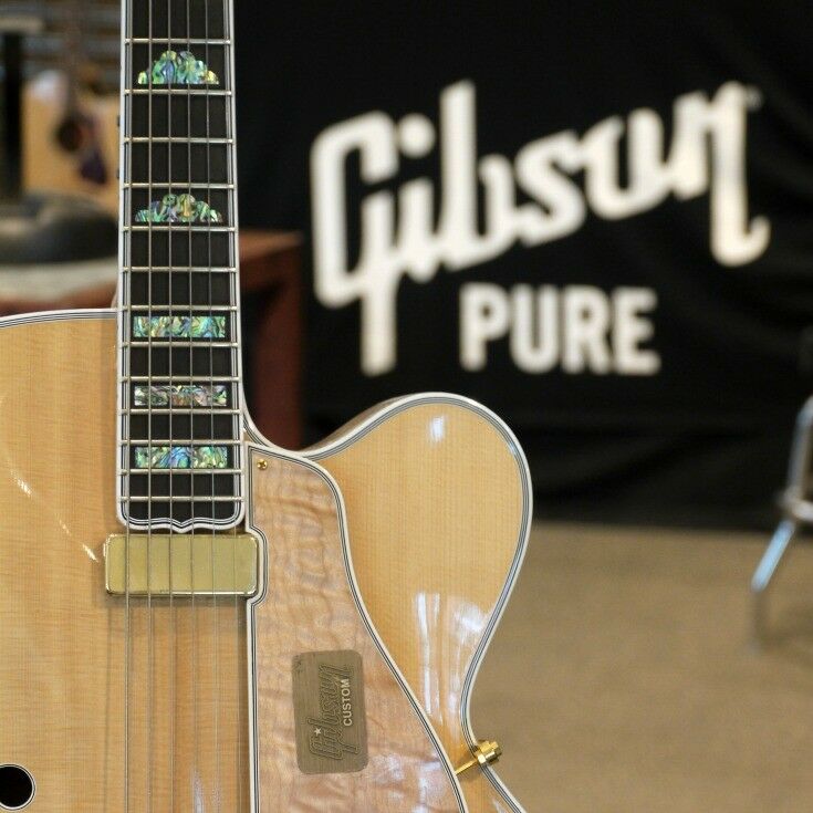 Close-up of the midsection of a mother-of-pearl inlaid maple topped custom electric guitar. 