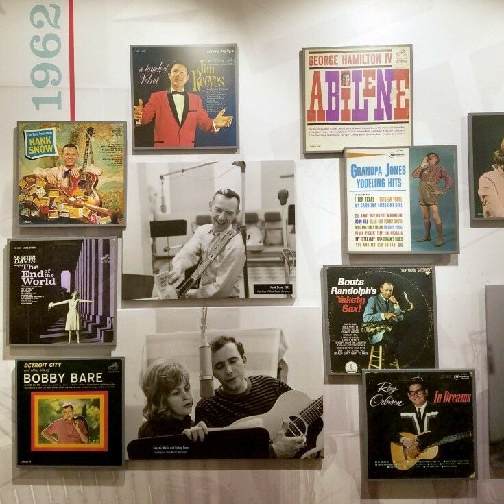 Various album covers and artist images on a wall. 