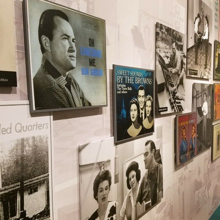 Various album covers and artist images on a wall. 