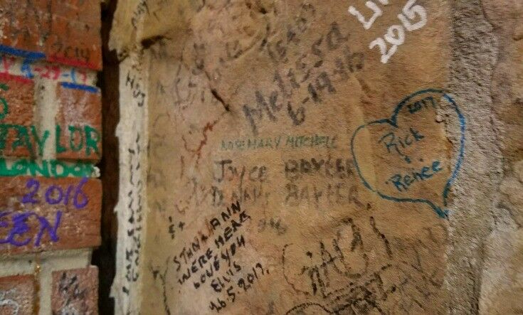 Close-up of Graceland signing wall, with names written in various colored pens. 