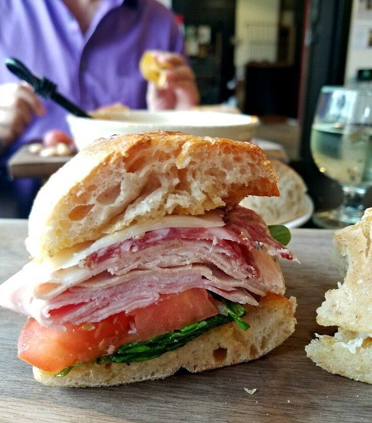 Ham and turkey, thin slices of sopressata and mortadella (Italian salamis), and gruyere cheese on a bakery-fresh baguette,