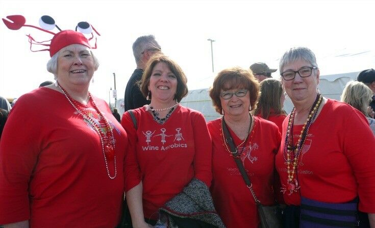 Four middle-aged women wearing matching red sweatshirts.
