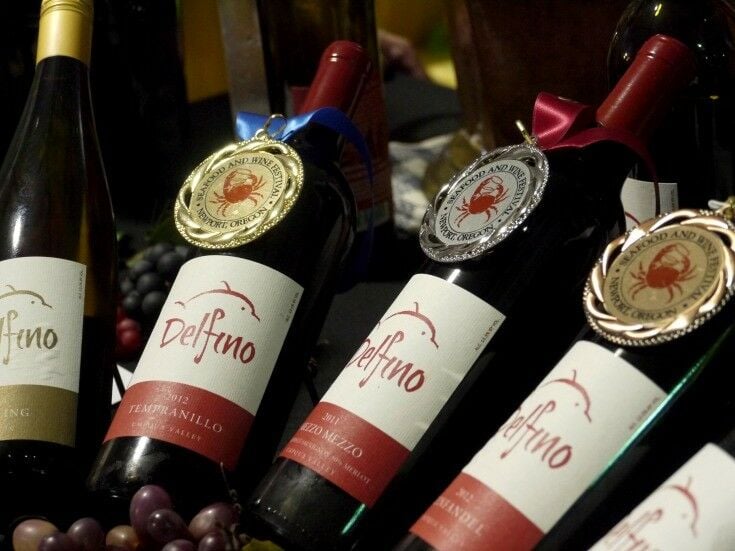 Bottles of Delfino wine with medals hanging from them. 