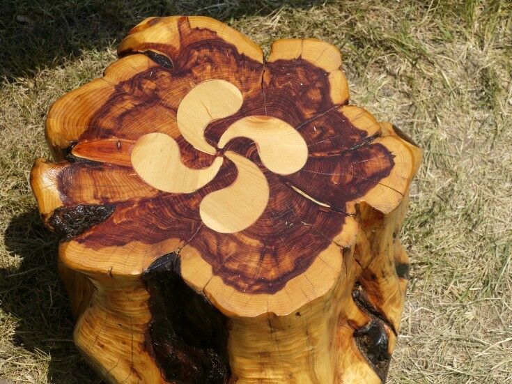 Wooden stool with an inlaid lauburu motif.